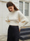 Cream knit sweater with open back and tie detail, front view