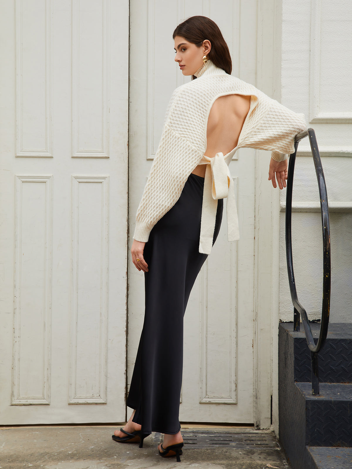 Cream knit sweater with open back and tie detail, three-quarter back view