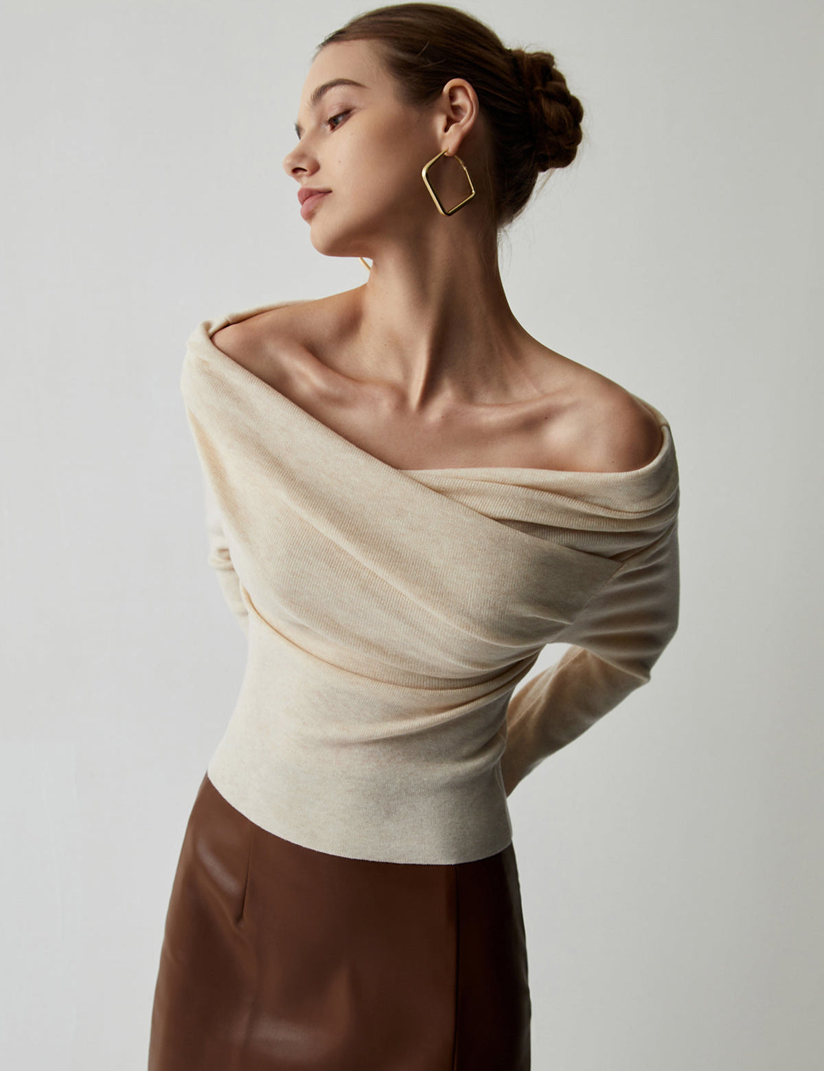 Off-shoulder cream sweater with draped neckline, side view