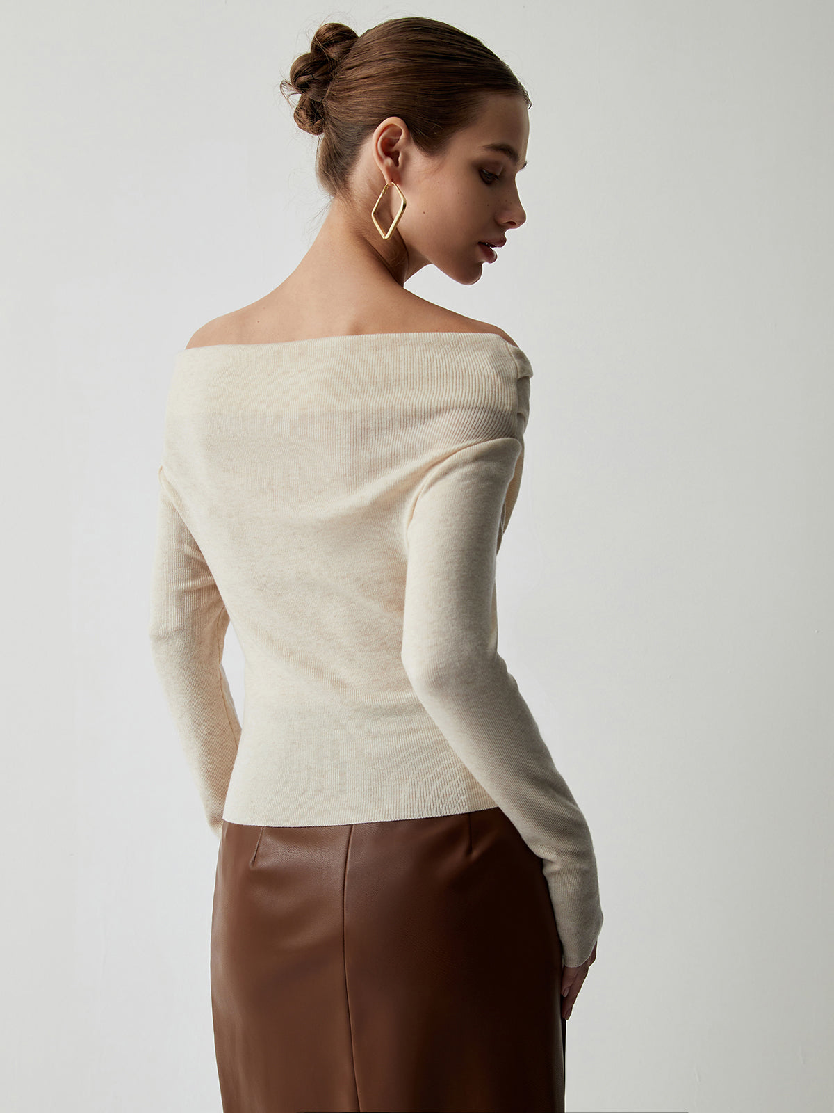 Cream off-shoulder sweater with draped neckline, back view