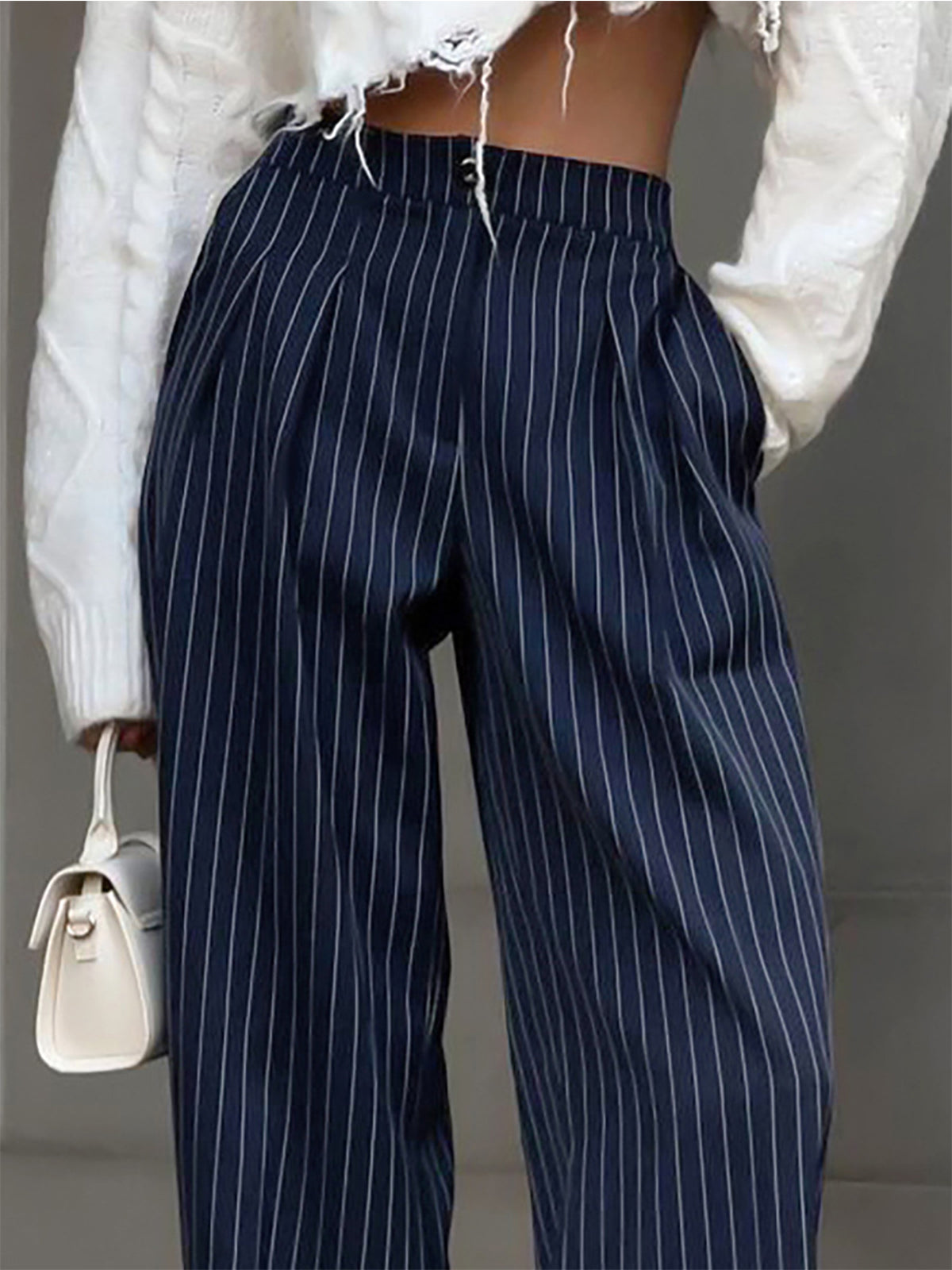 Navy pinstripe trousers with white sweater and bag