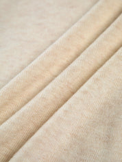 Cream off-shoulder sweater fabric detail, close-up