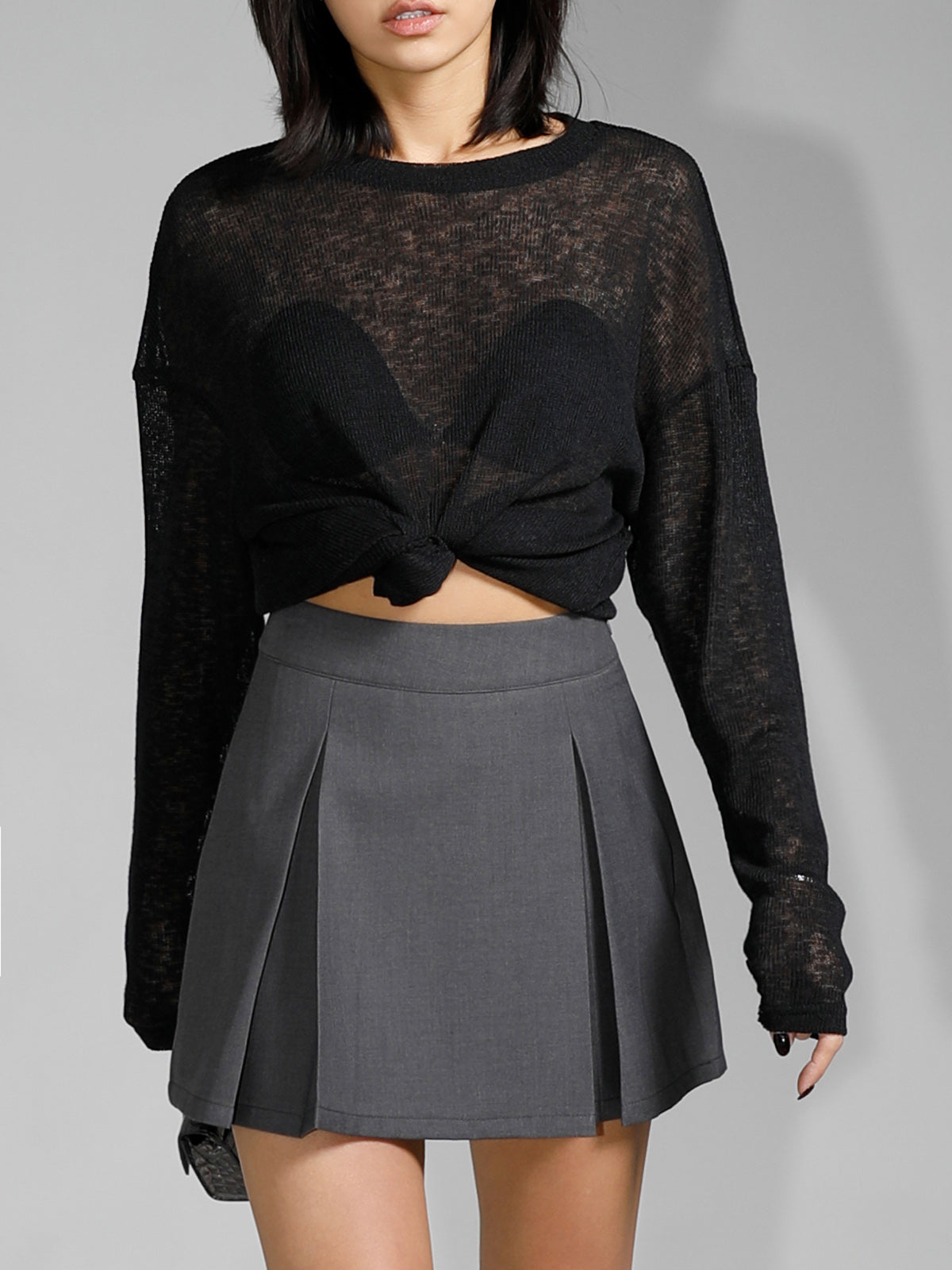 Off-shoulder sheer black sweater with pleated skirt detail