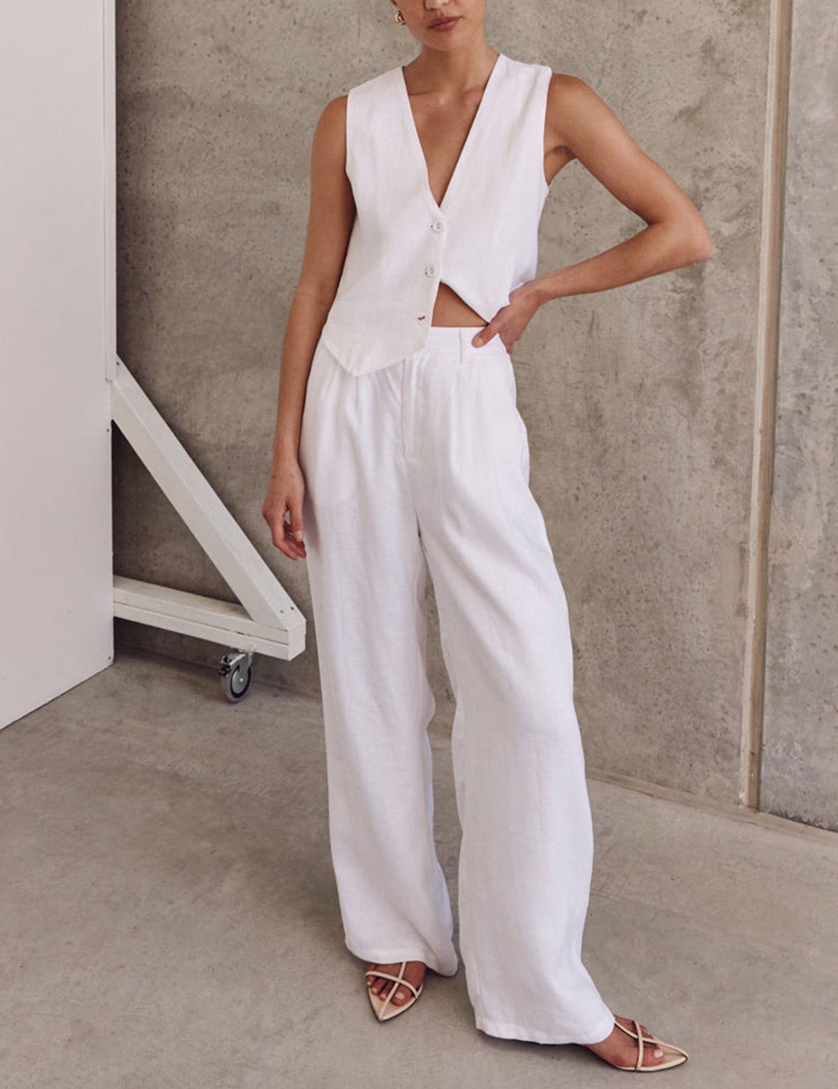 White linen set with wide-leg pants and buttoned top, side profile