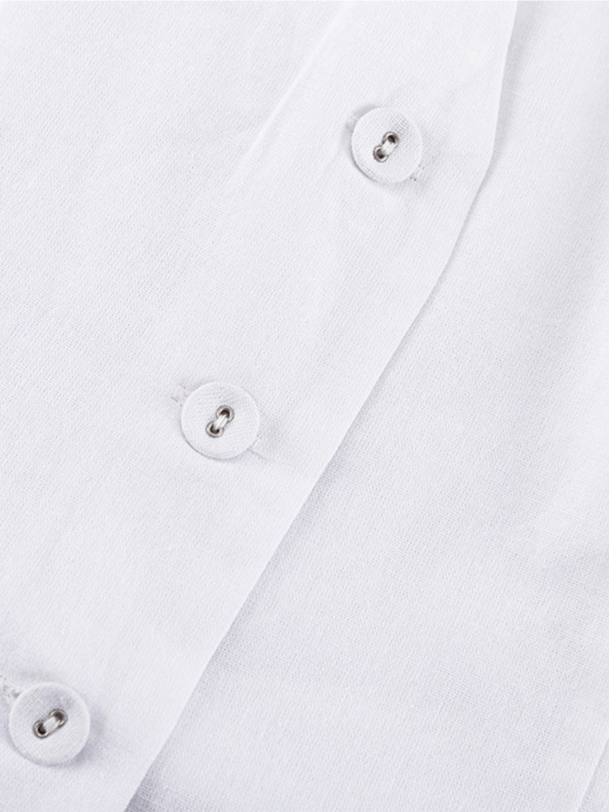 White linen buttoned top detail shot, showcasing fabric texture and buttons