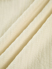 Cream dress fabric detail, textured crinkled material