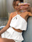 Gold metal necklace on white top and white shorts front view