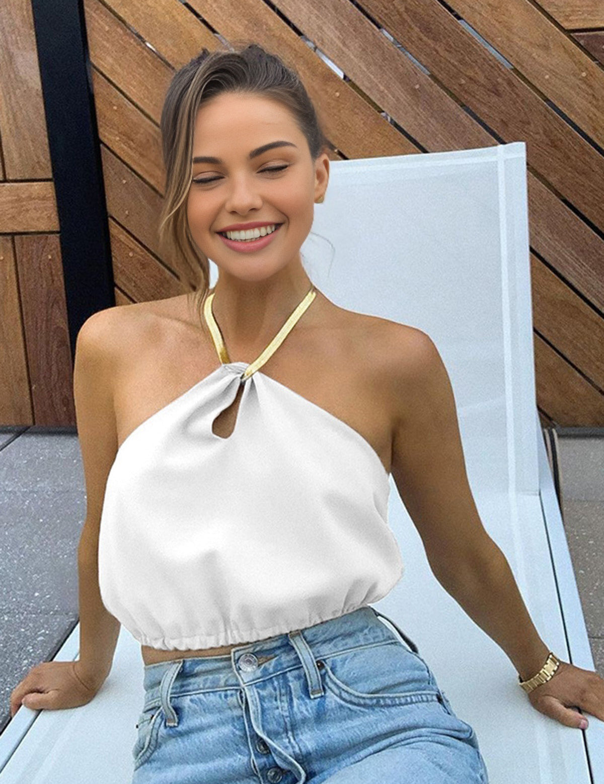 Gold metal necklace on white top and jeans side view