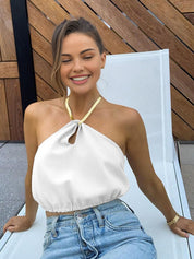 Gold metal necklace on white top and jeans side view