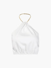 Gold metal necklace on white top isolated view