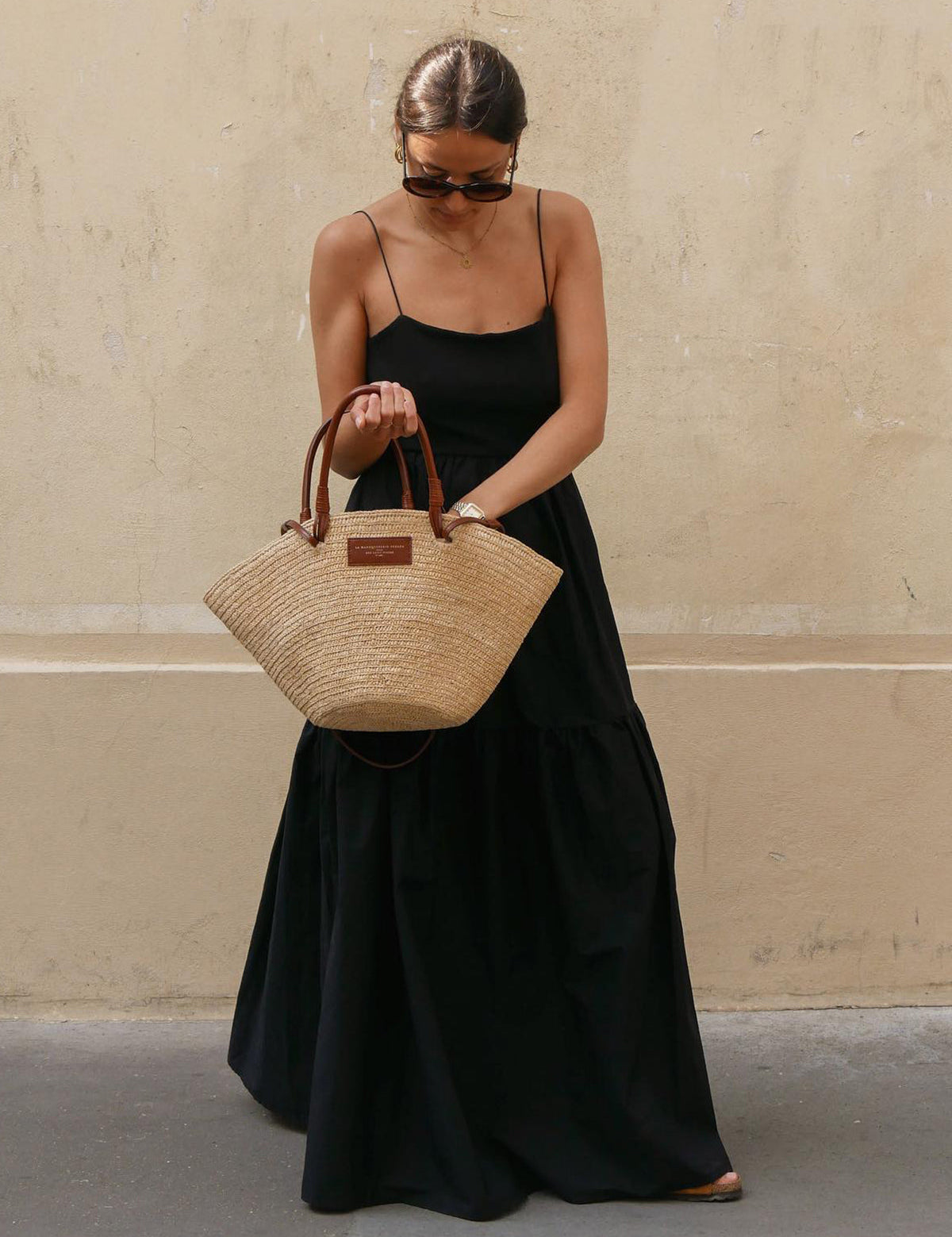 Black maxi dress with thin straps, front view with handbag