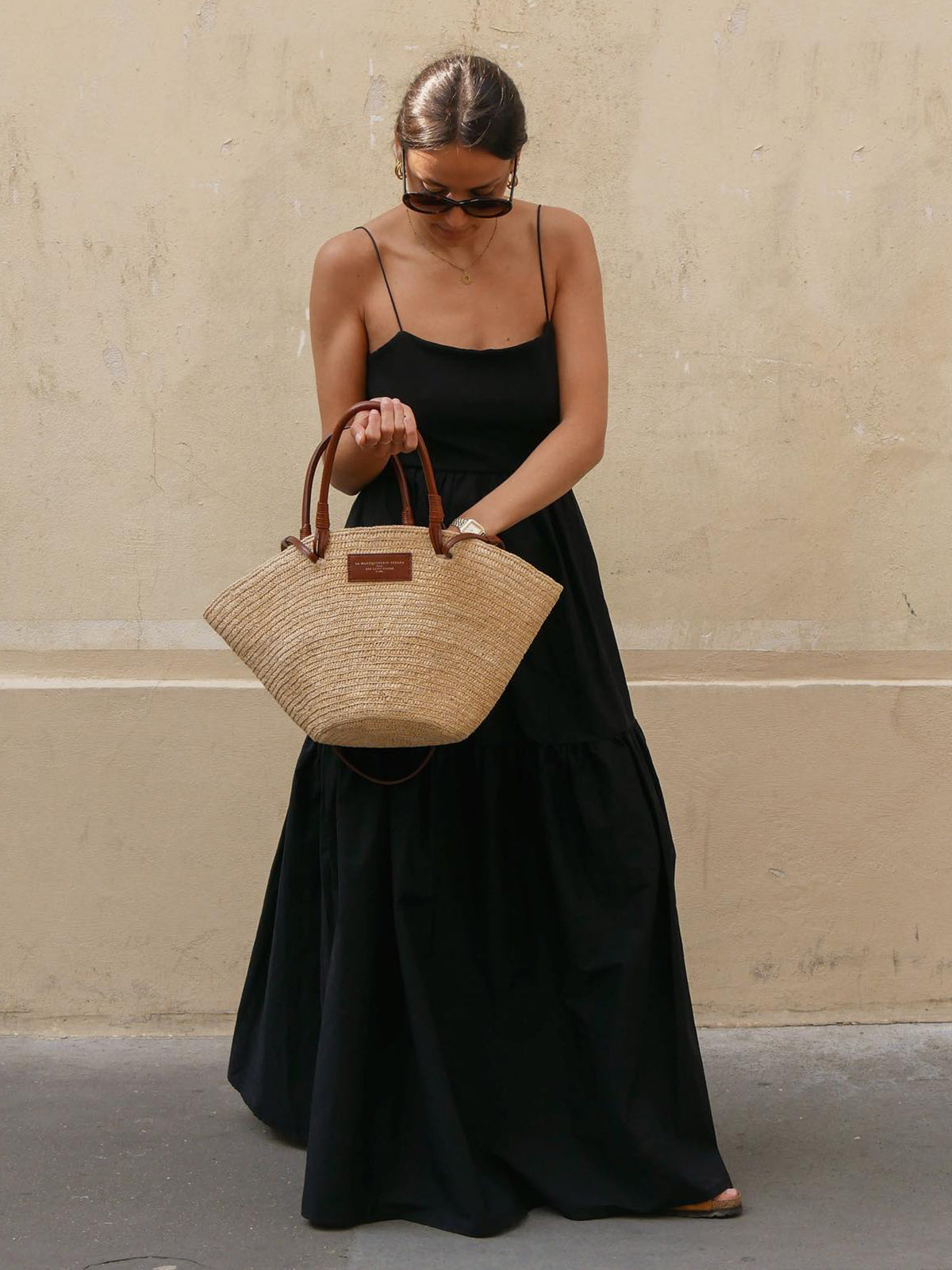 Black maxi dress with thin straps, front view with handbag