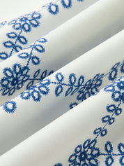 Fabric detail white with blue floral embroidery close-up