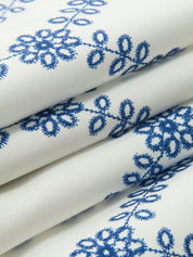 Fabric texture white with blue floral embroidery close-up