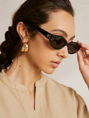 Cat-eye sunglasses with silver hardware worn by model, side view