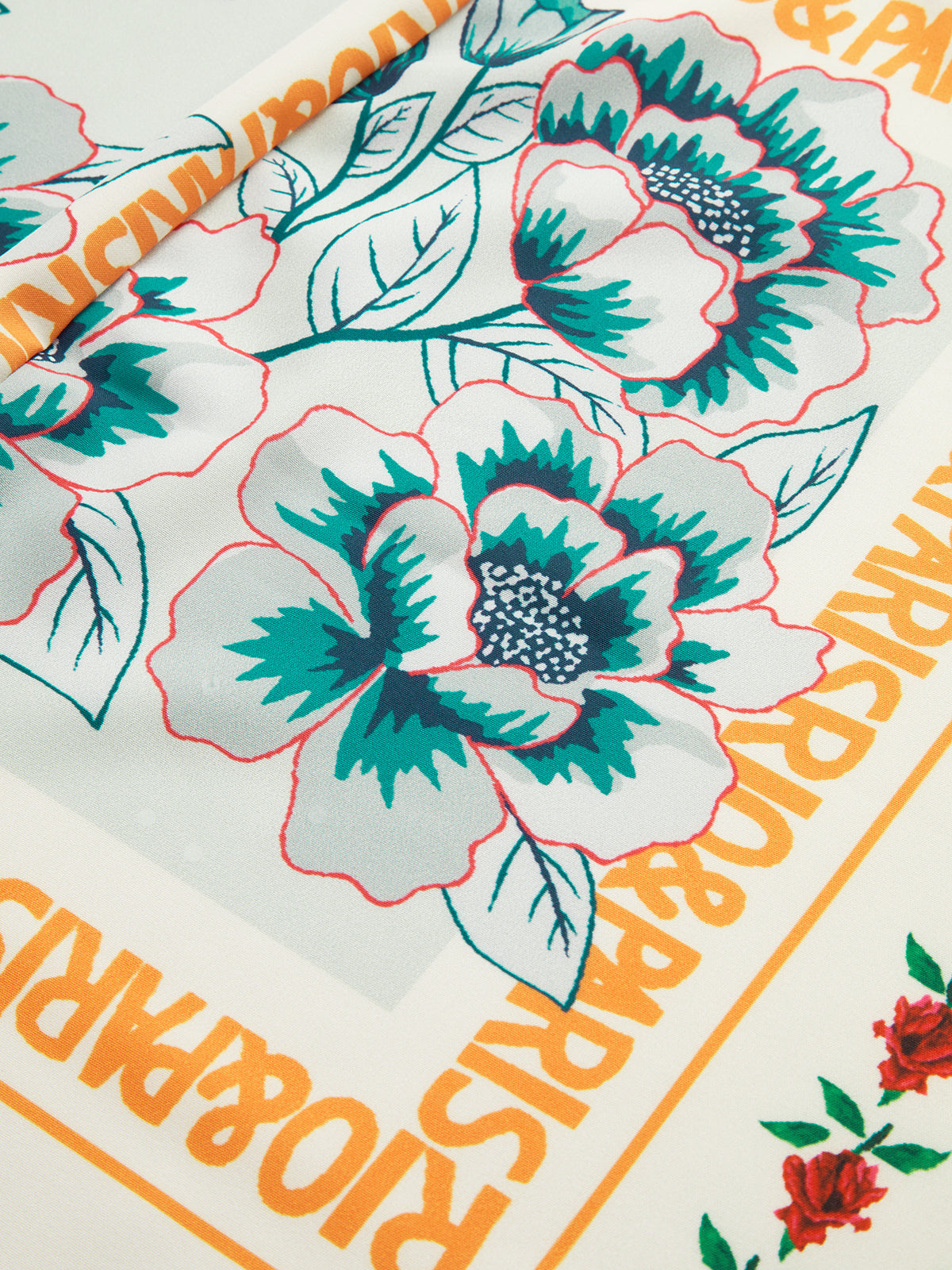 Close-up of floral print with bold orange text and green accents