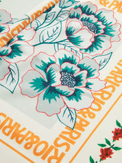 Close-up of floral print with bold orange text and green accents