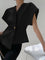 Black V-neck top with gold button detail, side view