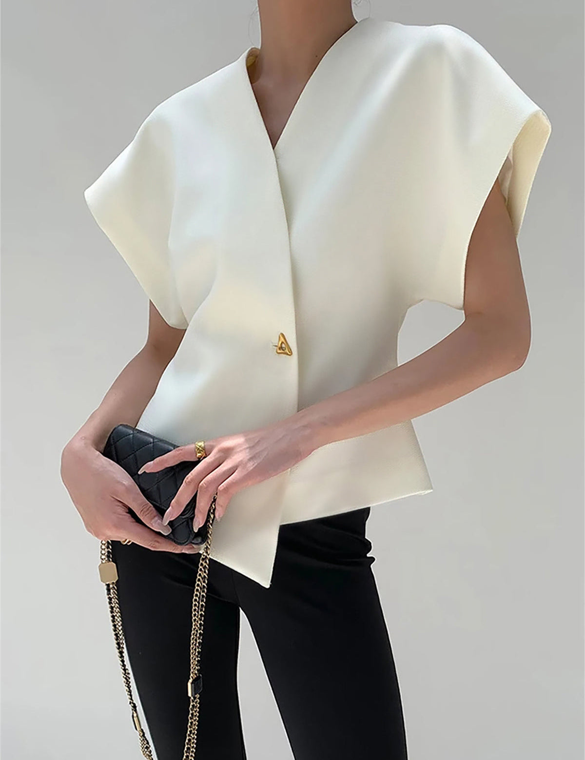 White V-neck top with gold button detail, front view