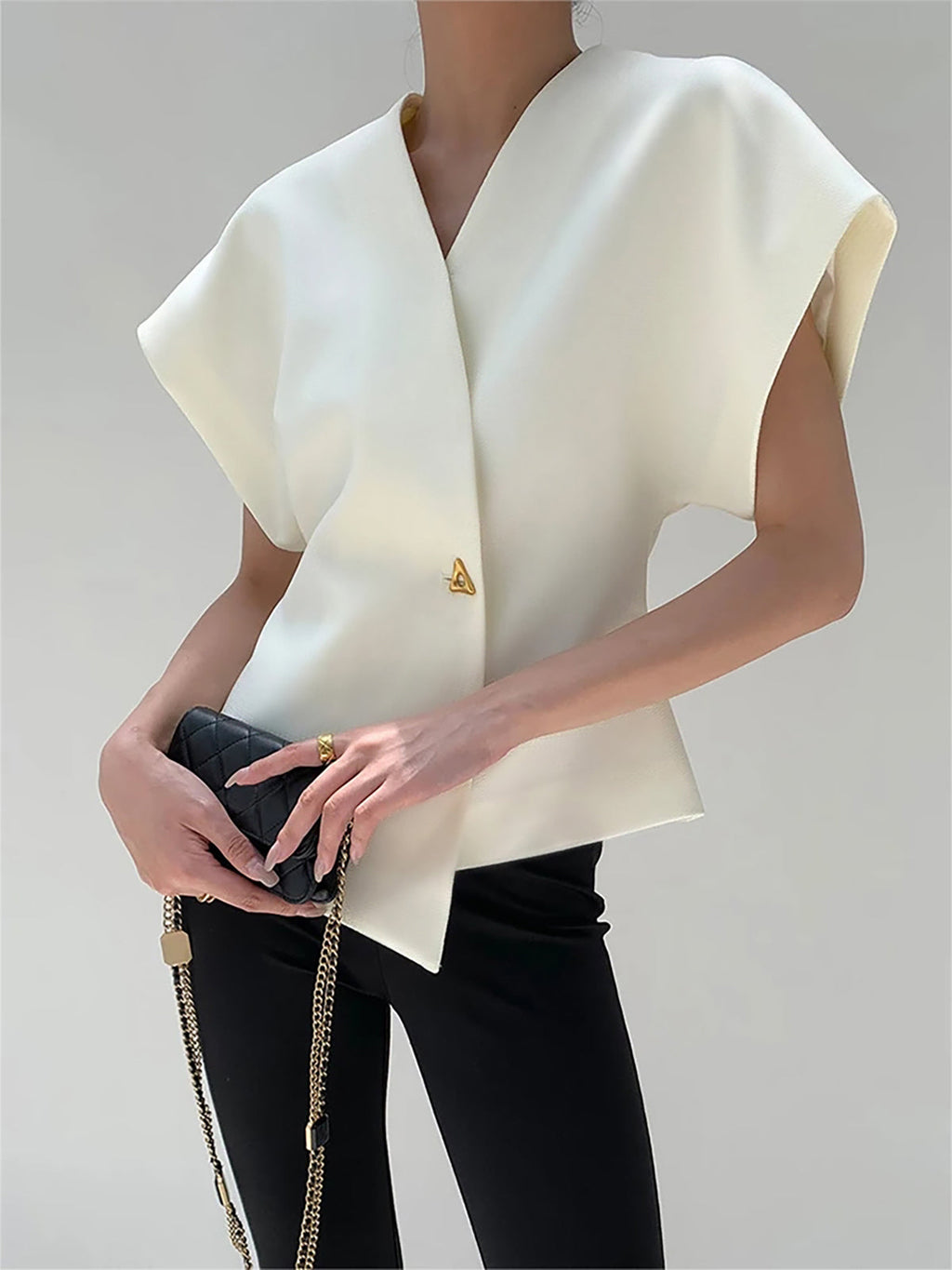 White V-neck top with gold button detail, front view