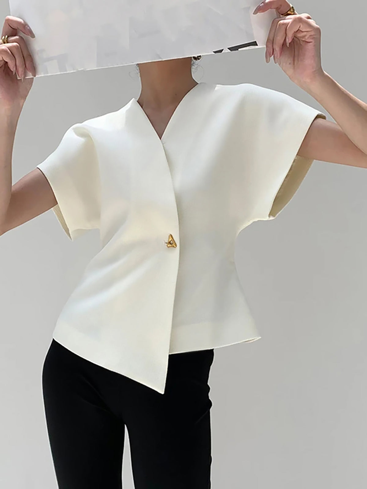 White V-neck top with gold button detail, side profile