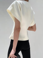 White V-neck top with gold button detail, front view with handbag