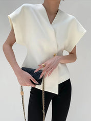 White V-neck top with gold button detail, front view with handbag
