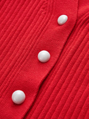 White buttons on red ribbed cardigan close-up