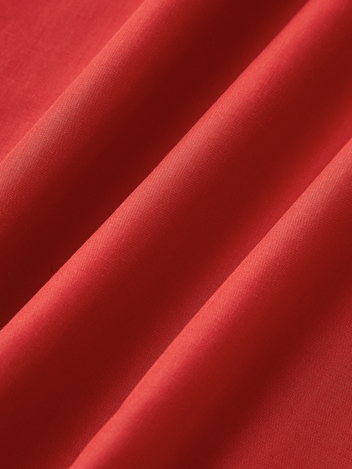 Red fabric detail with smooth texture and diagonal folds