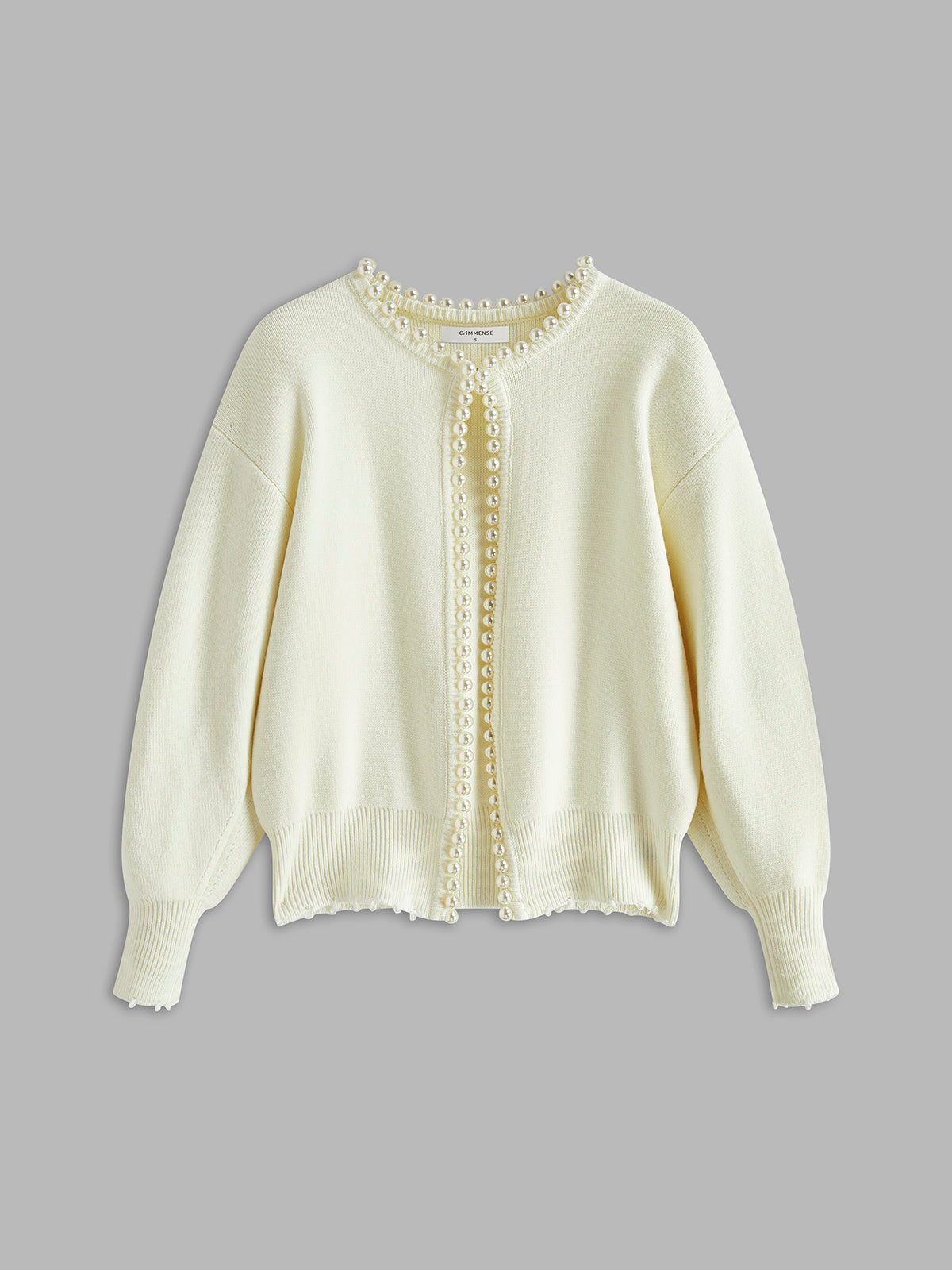 Cream cardigan with pearl embellishments flat lay front view