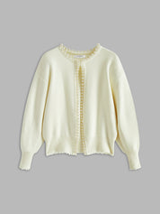 Cream cardigan with pearl embellishments flat lay front view
