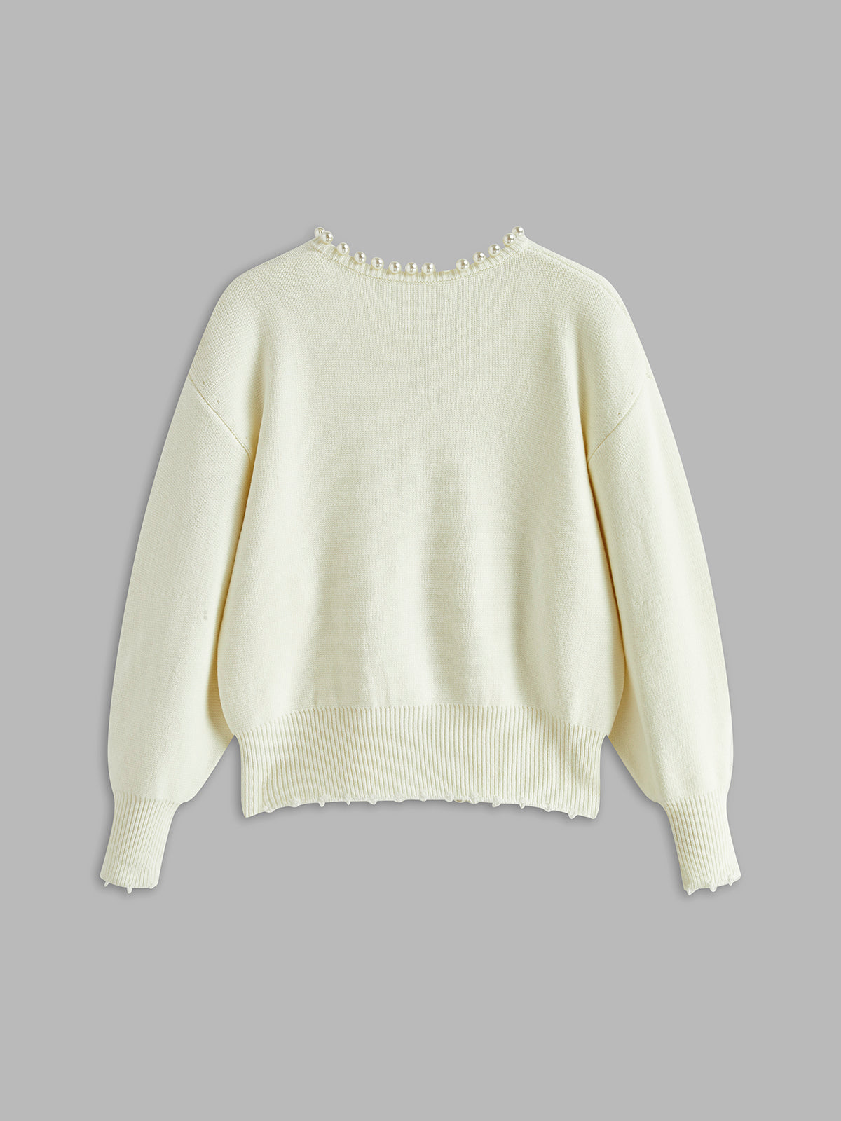 Cream cardigan with pearl embellishments flat lay back view
