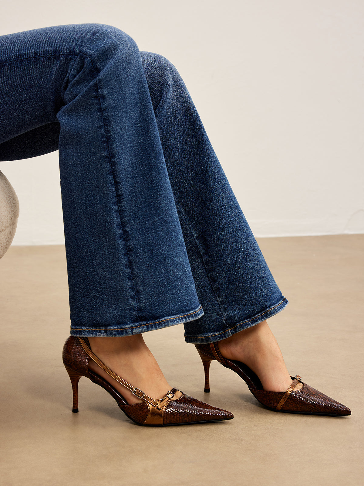 Brown snake print pumps worn with jeans close-up
