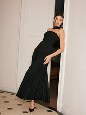 Black strapless evening dress with pleated skirt close-up upper body