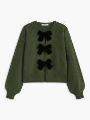 Cardigan green with black velvet bows front view plain background