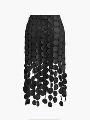 Evening skirt with circular cutouts and fringe detail, close-up view