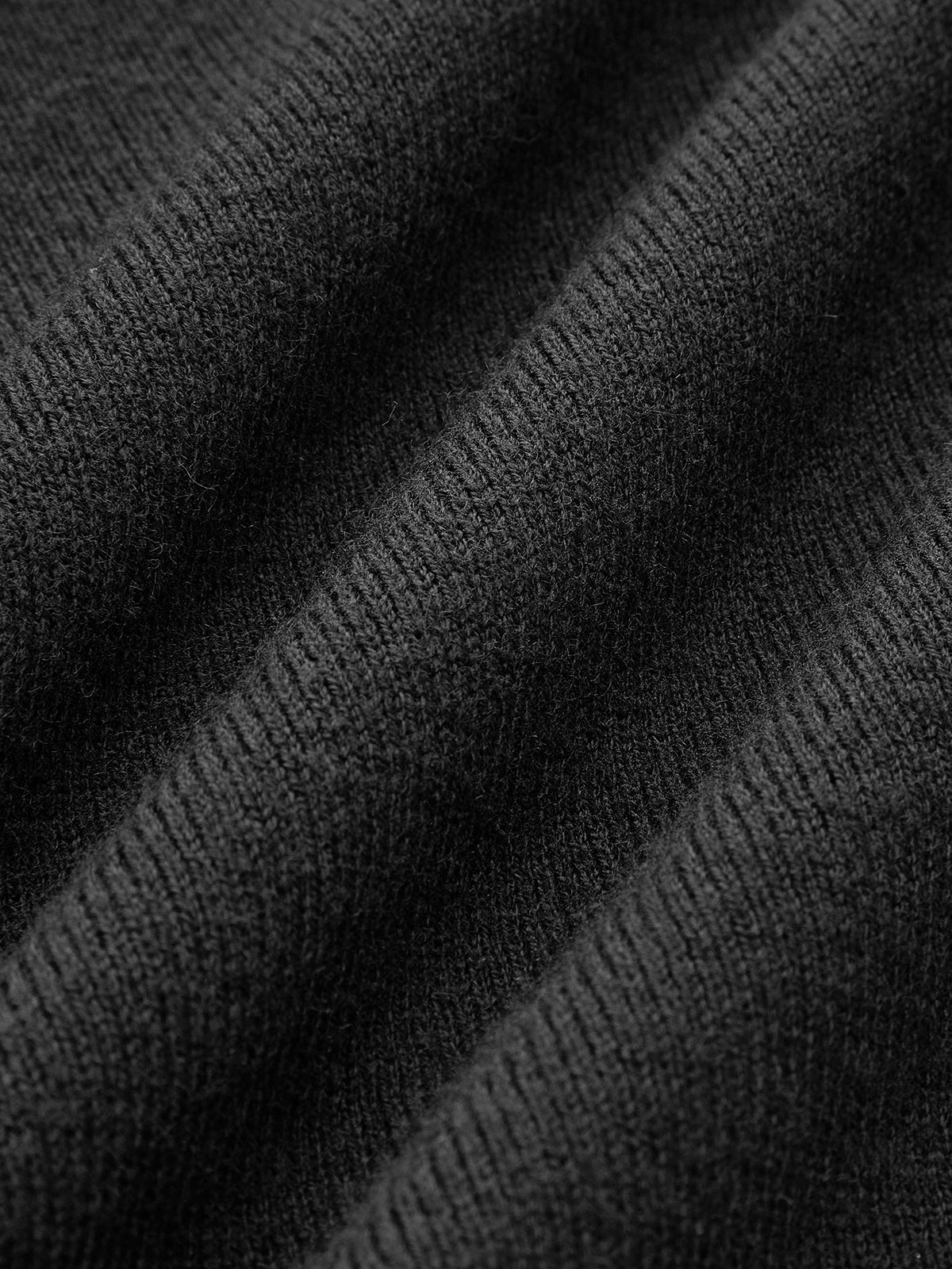 Black off-shoulder sweater fabric detail, close-up