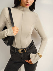 Khaki long-sleeve top with belt and black jeans front view