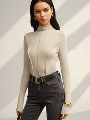 Khaki fitted top with gold belt buckle and black jeans side view