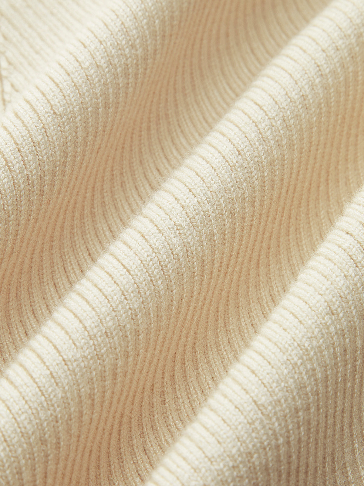 Close-up of cream ribbed knit fabric texture folded