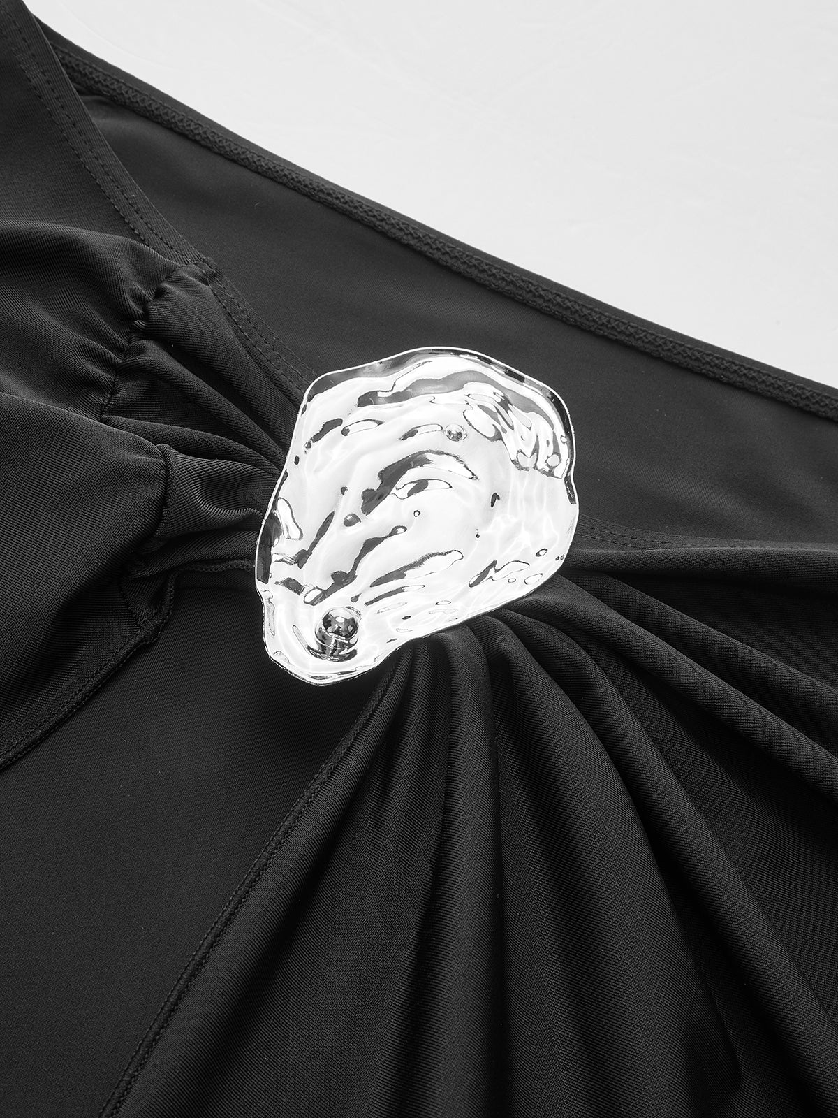 Gold embellishment on black silk maxi dress close-up