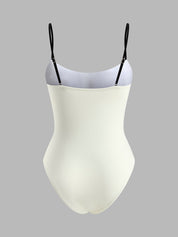 White swimsuit with black contrast straps, back view