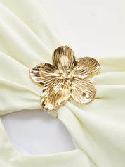 Gold flower detail on white one-piece swimsuit close-up