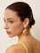 Gold shell-shaped earrings with textured detail, worn on ear, side view