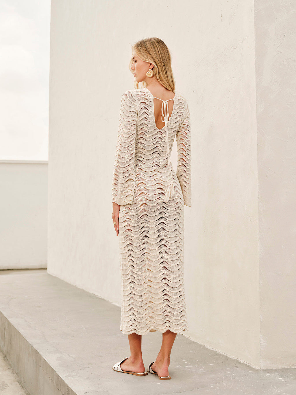 Cream lace dress with bell sleeves and tie back detail back view