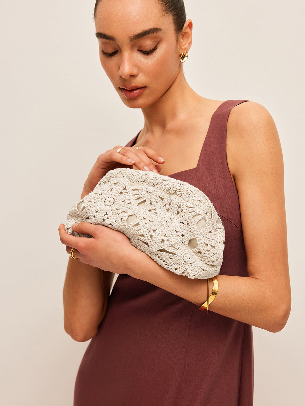Woman holding crochet clutch bag white