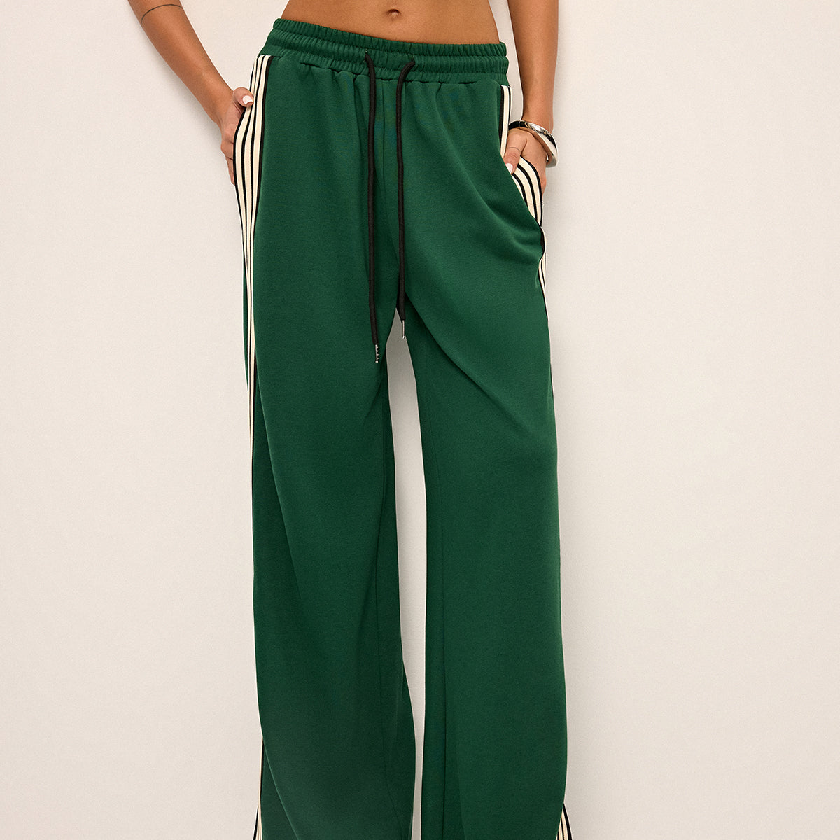 Green joggers with white and black stripes front view hands in pockets