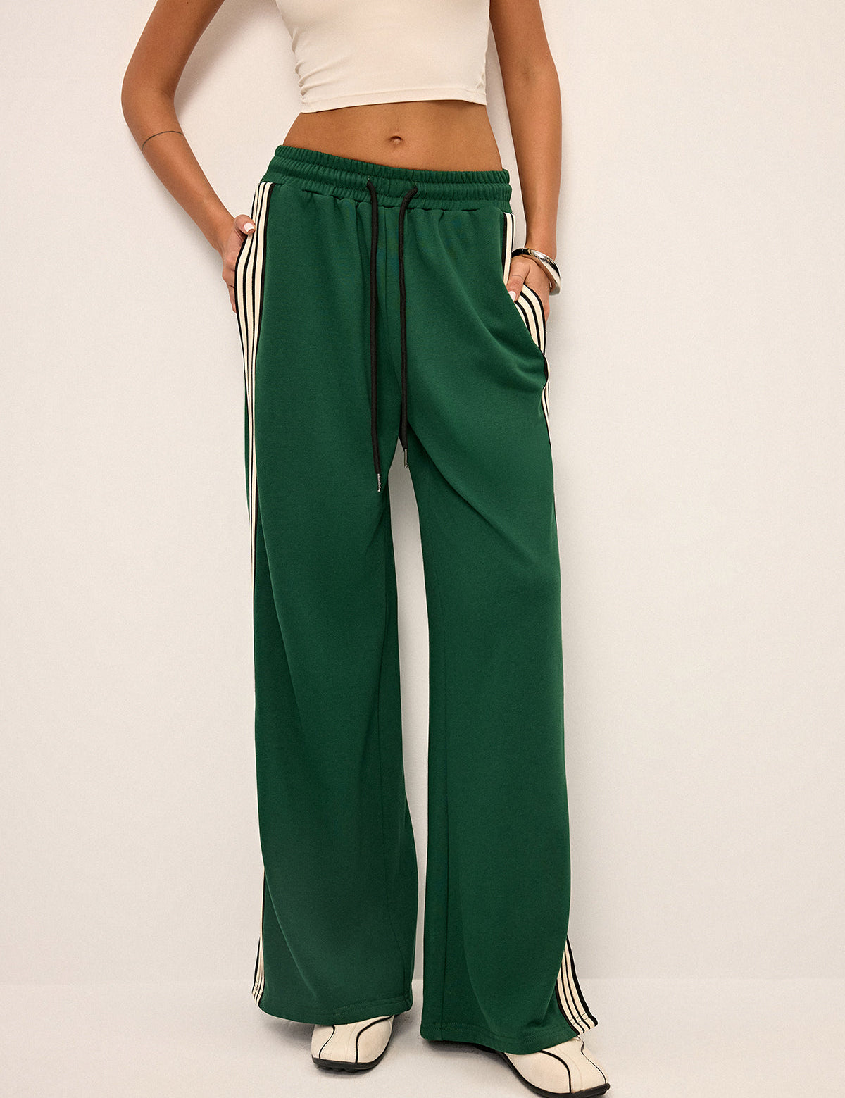 Green joggers with white and black stripes front view hands in pockets