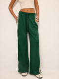 Green joggers with white and black stripes front view hands in pockets