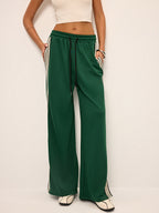 Green joggers with white and black stripes front view hands in pockets